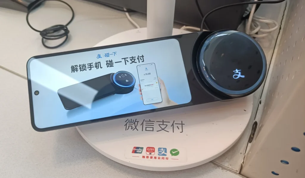 Alipay tap-to-pay terminal with Weixin Pay marked on the stand