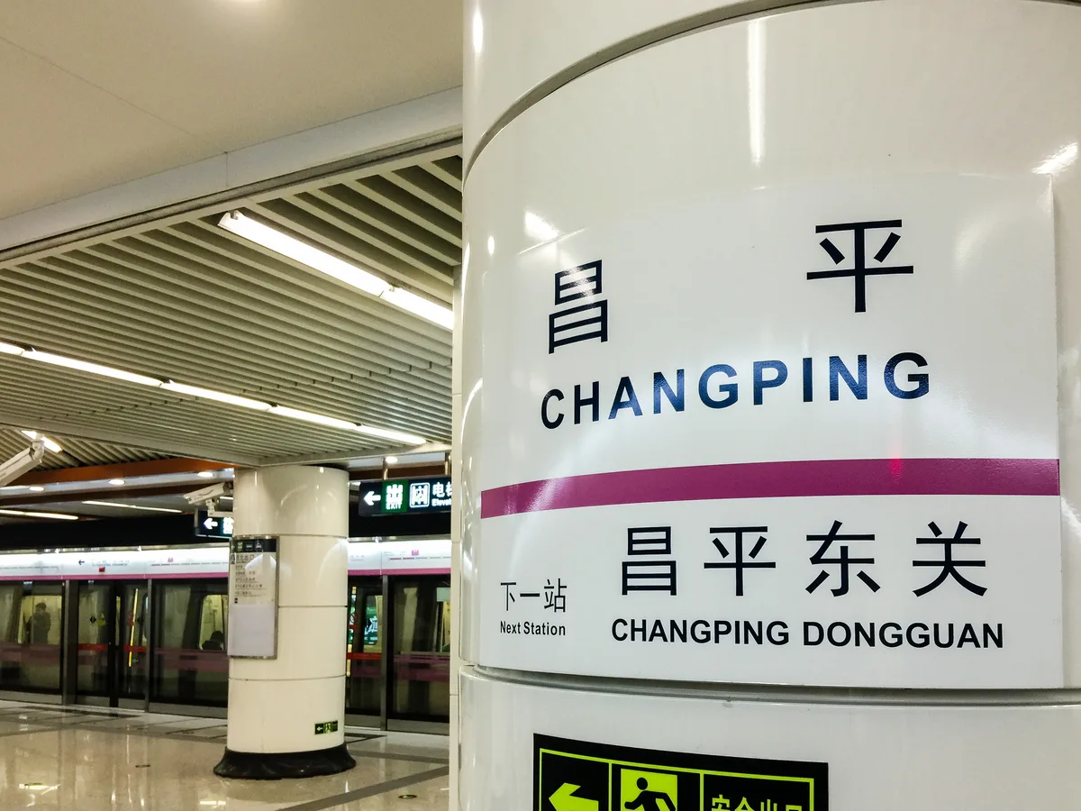 Station sign and platform at Changping on the Beijing Subway, with the next station in Chinese and English