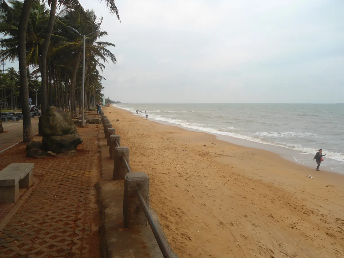 Palm-lined promenade and sandy beach at Holiday Beach in Haikou