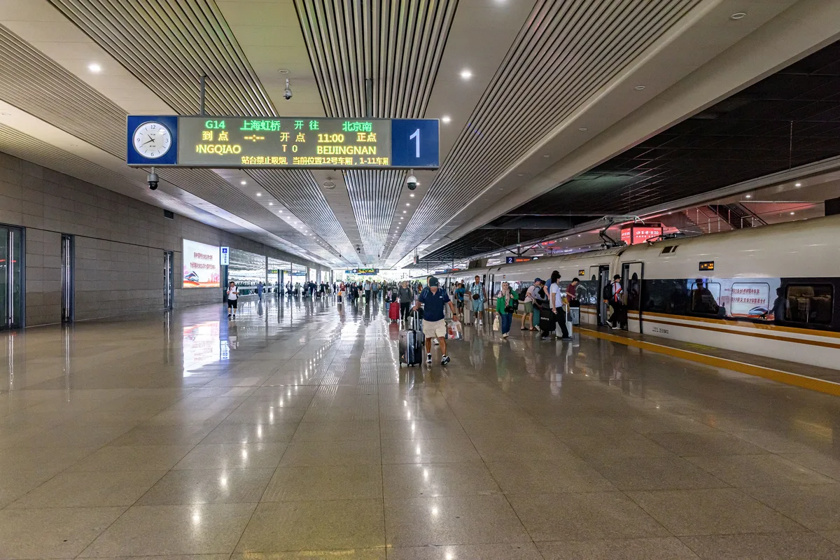 Passengers beside a high-speed train at Shanghai Hongqiao railway station